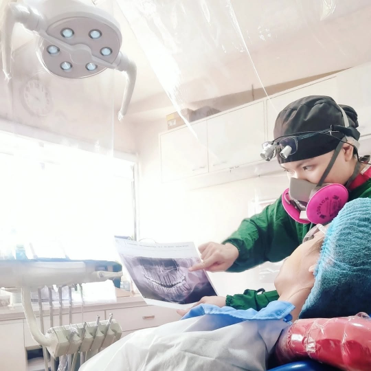 Dentist showing a patient their dental x-ray to explain the tooth extraction procedure.