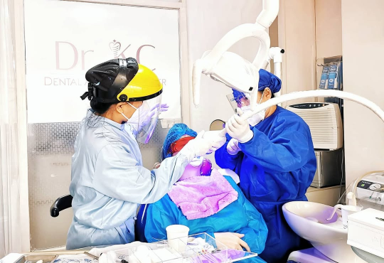 Dentist performing a laser teeth whitening on a patient.